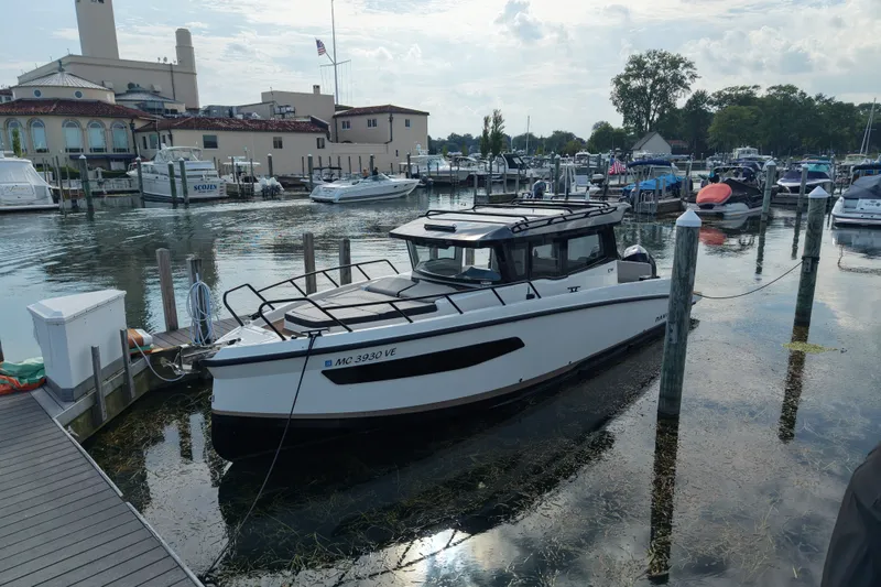 Slide: The Image of 2025 Navan C30 boat docked at a marina with surrounding boats and buildings. - 17