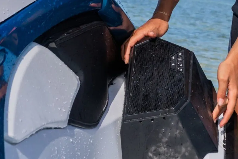 Slide: The Image of 2027 Yamaha WaveRunner JetBlaster LTD with detachable speaker, hands adjusting it by the water. - 5