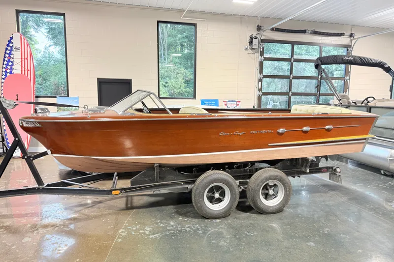 The Image of 1955 Chris Craft Chriscraft boat on trailer in indoor showroom. - 1