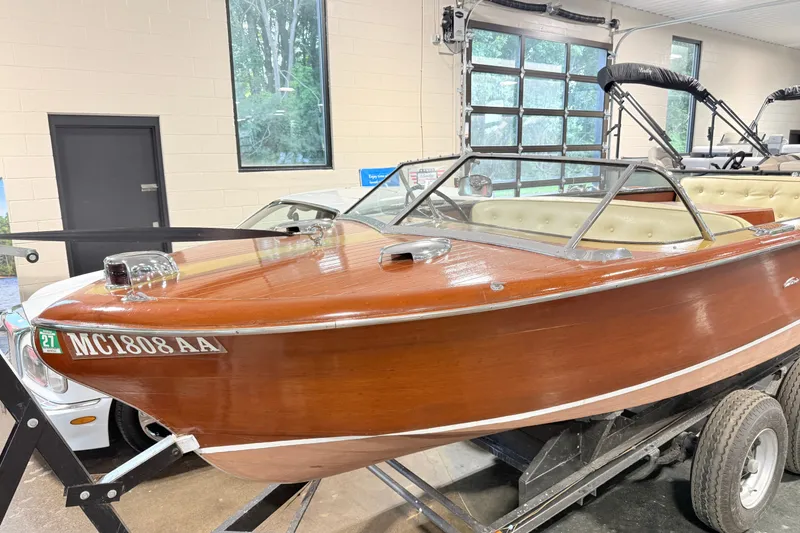 Slide: The Image of 1955 Chris Craft Chriscraft wooden boat displayed indoors on a trailer. - 2