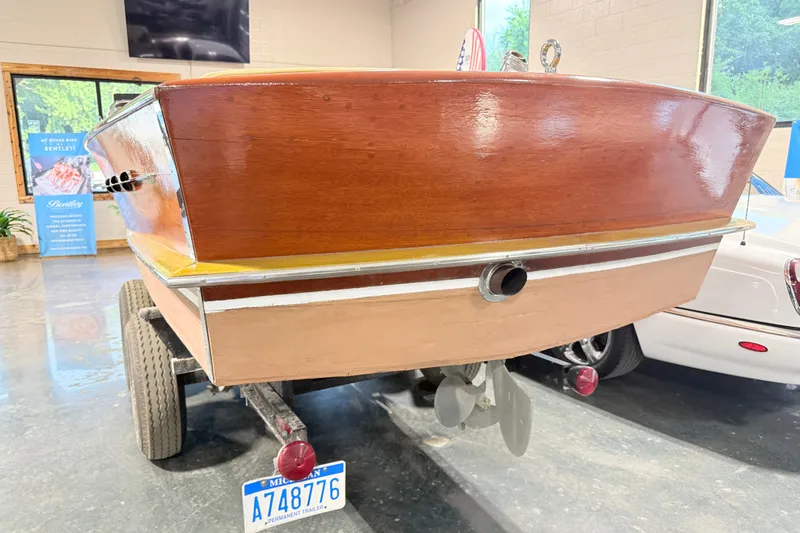 Slide: The Image of 1955 Chris Craft Chriscraft boat on trailer, showcasing polished wooden hull. - 10