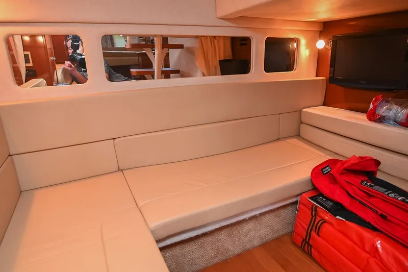 Slide: The Image of Interior of 2011 Sea Ray Sundancer 330 with beige seating and a mounted TV. - 46