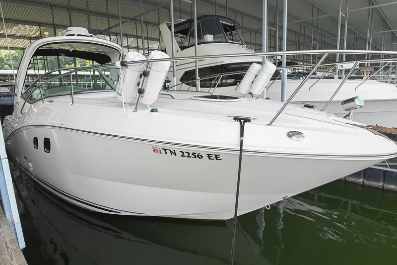 Slide: The Image of 2011 Sea Ray Sundancer 330 docked in a marina, showcasing sleek design and white exterior. - 0