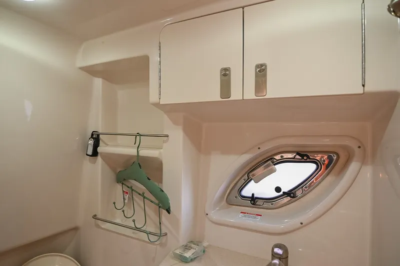 Slide: The Image of Interior of 2011 Sea Ray Sundancer 330 with cabinet, porthole, and hangers. - 50