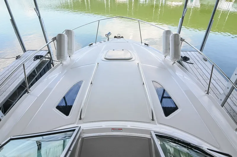 Slide: The Image of 2011 Sea Ray Sundancer 330 yacht docked, showcasing sleek deck design and water reflection. - 26