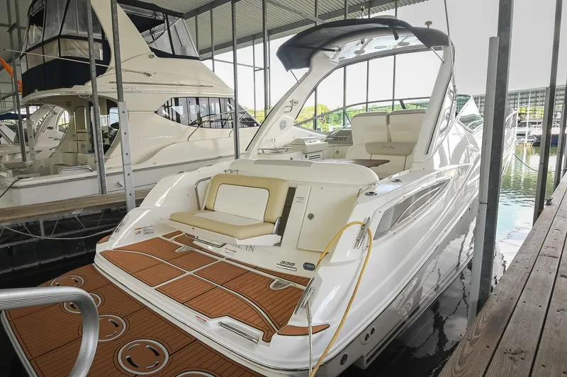 Slide: The Image of 2011 Sea Ray Sundancer 330 yacht docked in a marina, showcasing sleek design and spacious deck. - 4