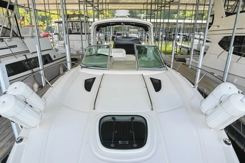 Slide: The Image of 2011 Sea Ray Sundancer 330 yacht docked in a marina, showcasing sleek design and spacious deck. - 27