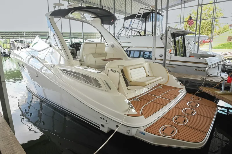 Slide: The Image of 2011 Sea Ray Sundancer 330 yacht docked in a marina, showcasing sleek design and spacious deck. - 5