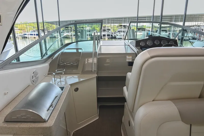Slide: The Image of 2011 Sea Ray Sundancer 330 cockpit with helm, seating, and outdoor grill. - 12