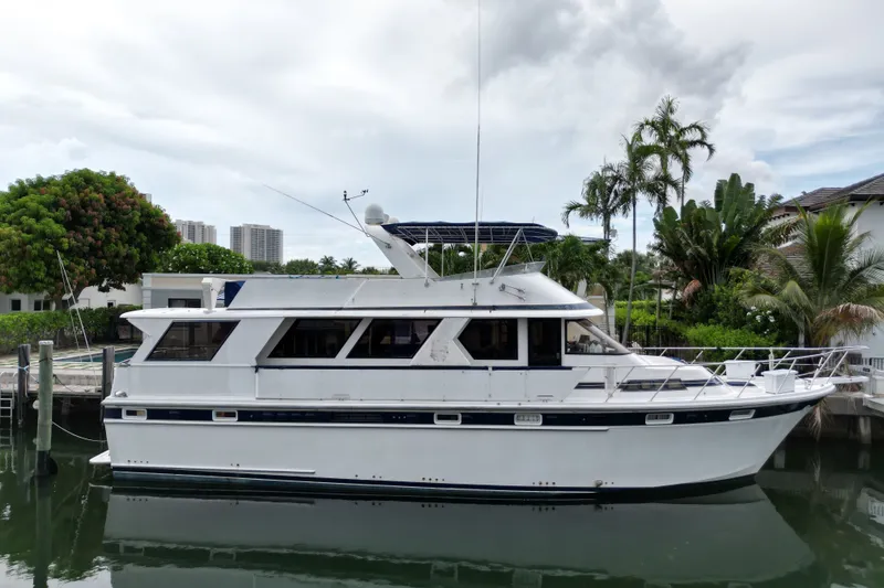Slide: The Image of 1988 Jefferson Marquessa 60 MY yacht docked near lush greenery and waterfront homes. - 2