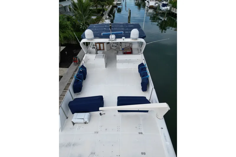 Slide: The Image of 1988 Jefferson Marquessa 60 MY yacht deck with blue seating, docked near palm trees. - 8