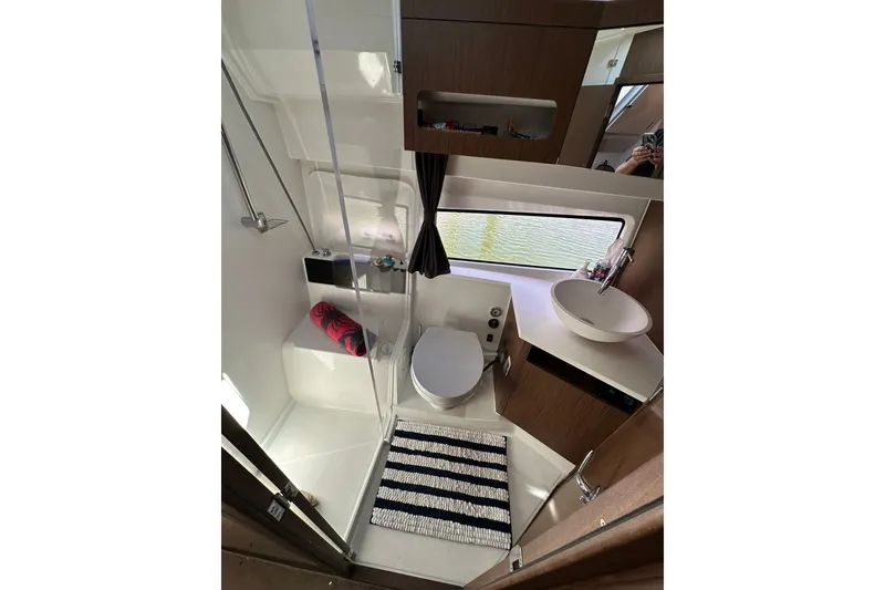 Slide: The Image of 2024 Beneteau Antares 11 Fly bathroom with modern fixtures and striped rug. - 80