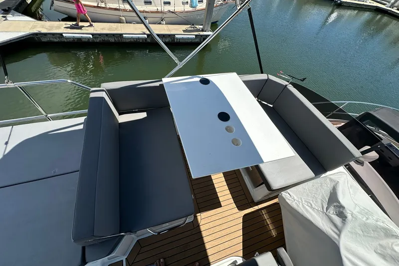 Slide: The Image of 2024 Beneteau Antares 11 Fly deck with seating and table, docked at marina. - 25