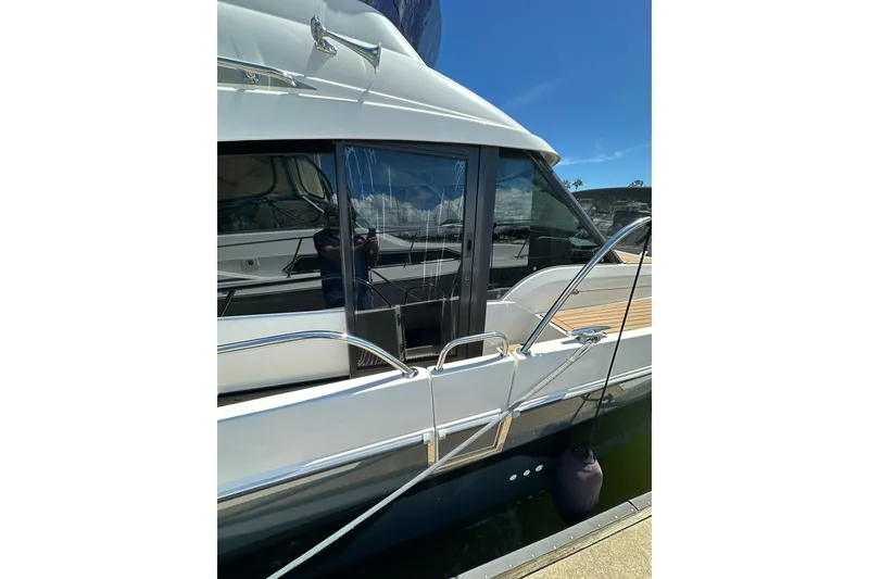 Slide: The Image of 2024 Beneteau Antares 11 Fly yacht, sleek design with glass doors and chrome railings. - 11