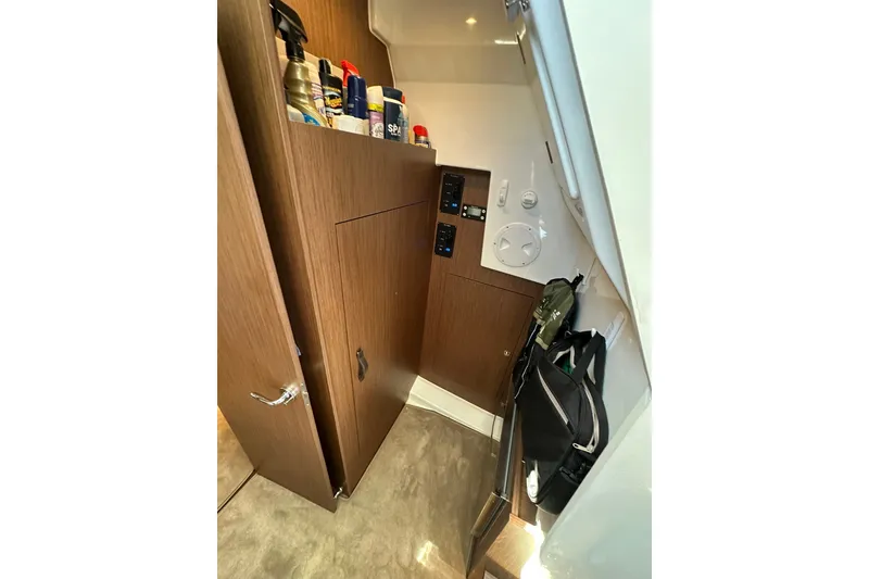 Slide: The Image of Interior storage area of 2024 Beneteau Antares 11 Fly with wooden cabinetry and control panels. - 78