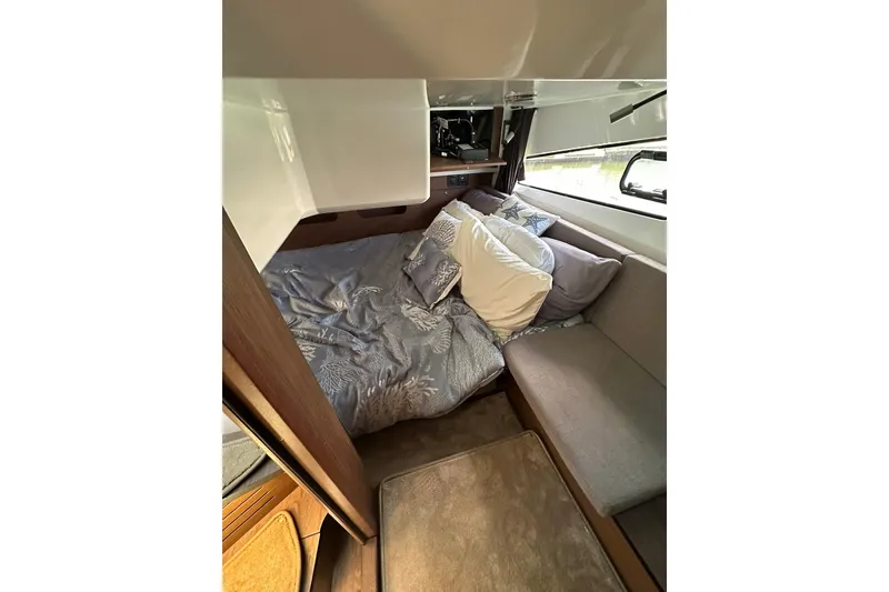 Slide: The Image of 2024 Beneteau Antares 11 Fly cabin interior with cozy bedding and seating area. - 73