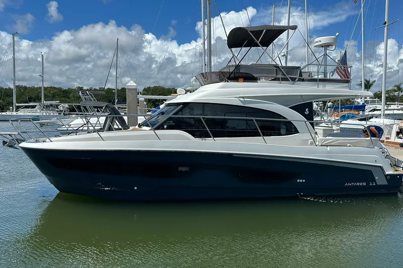 The Image of 2024 Beneteau Antares 11 Fly yacht docked in a marina under a cloudy sky. - 0