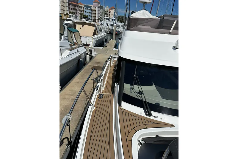 Slide: The Image of 2024 Beneteau Antares 11 Fly yacht docked at marina, showcasing sleek design and deck. - 14