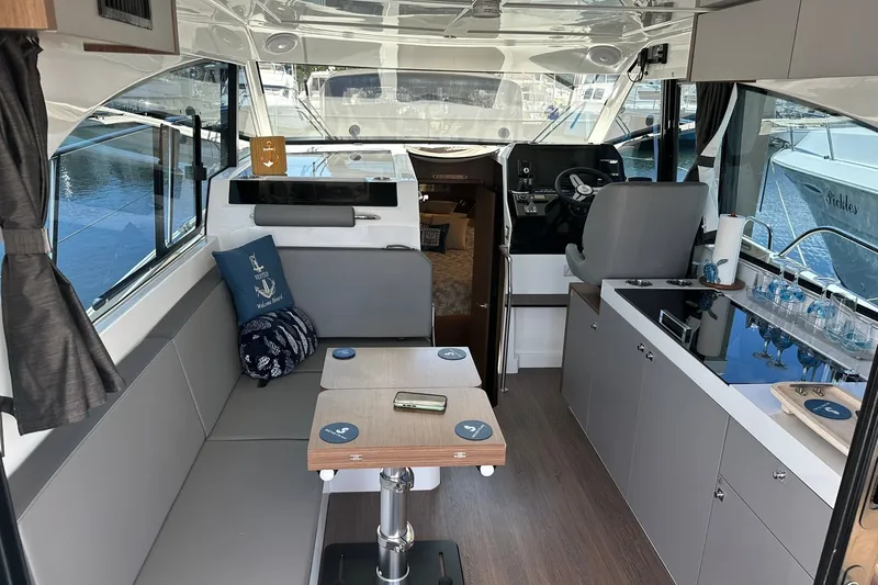 Slide: The Image of Interior of 2024 Beneteau Antares 11 Fly, featuring modern seating and kitchen area. - 57