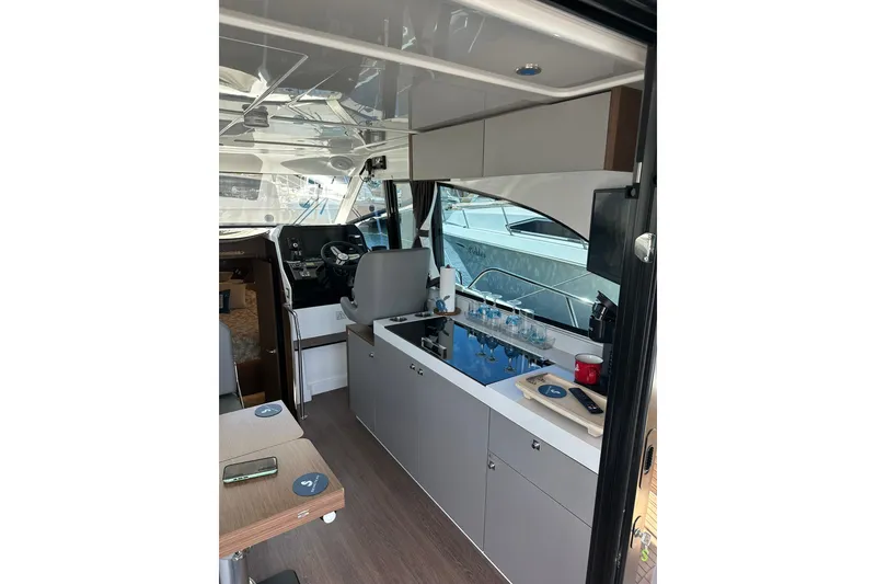 Slide: The Image of Interior of 2024 Beneteau Antares 11 Fly, featuring modern kitchen and helm station. - 56