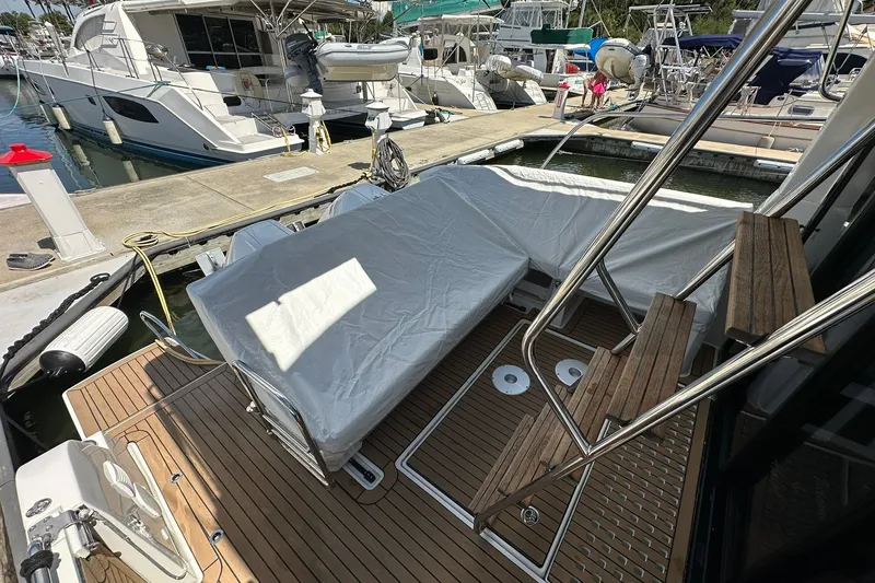 Slide: The Image of 2024 Beneteau Antares 11 Fly yacht docked, featuring covered seating and wooden deck. - 16
