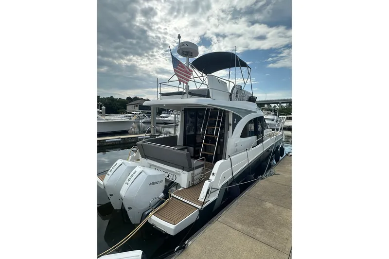 Slide: The Image of 2024 Beneteau Antares 11 Fly yacht docked, featuring twin Mercury engines and flybridge. - 4