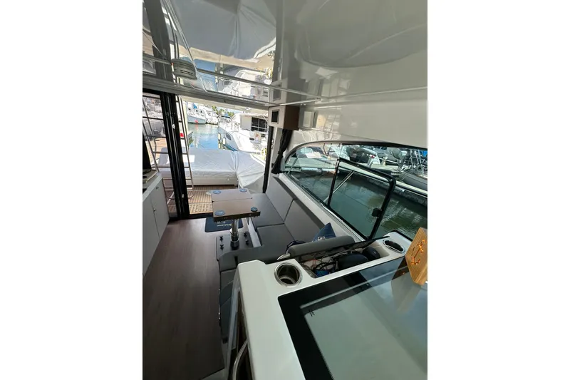 Slide: The Image of 2024 Beneteau Antares 11 Fly interior with seating and marina view. - 69