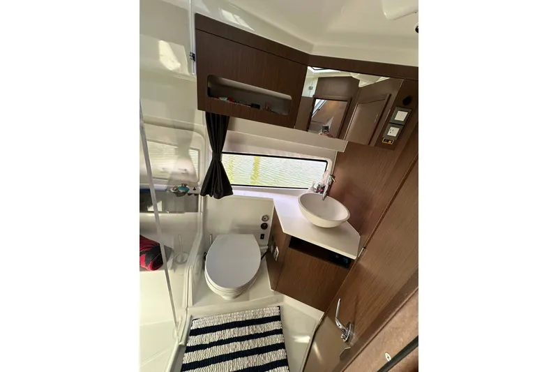 Slide: The Image of 2024 Beneteau Antares 11 Fly bathroom with modern fixtures and wood accents. - 82