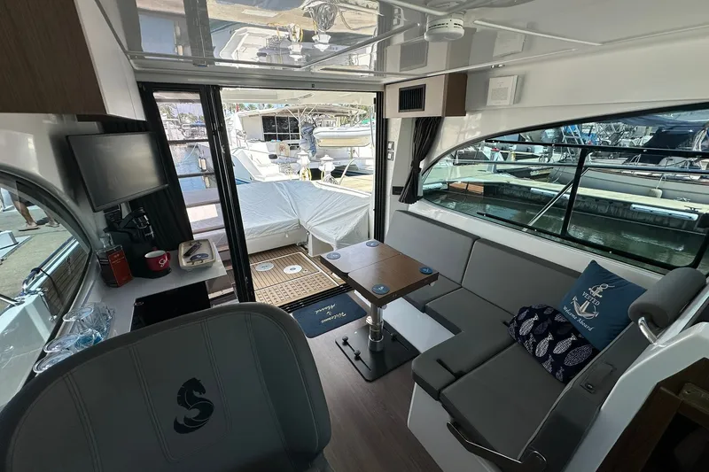 Slide: The Image of Interior of 2024 Beneteau Antares 11 Fly yacht, featuring modern seating and a compact table. - 67