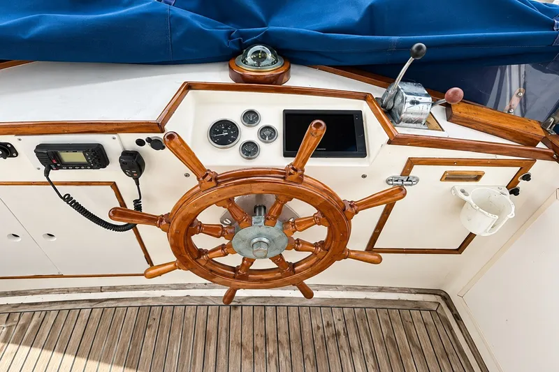 Slide: The Image of Wooden helm of a 1978 Grand Banks 36 Classic boat with navigation instruments. - 5
