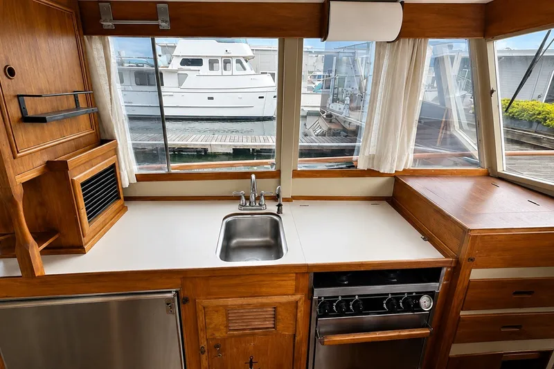 Slide: The Image of 1978 Grand Banks 36 Classic yacht kitchen with sink, stove, and wooden cabinetry. - 21