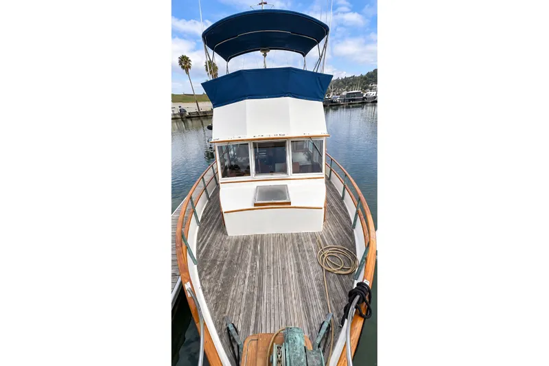 Slide: The Image of 1978 Grand Banks 36 Classic yacht with wooden deck and blue canopy in marina. - 2