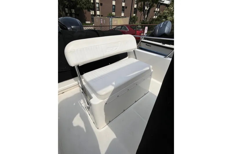 Slide: The Image of 2017 Boston Whaler 170 Montauk boat seat with white upholstery and storage compartment. - 13