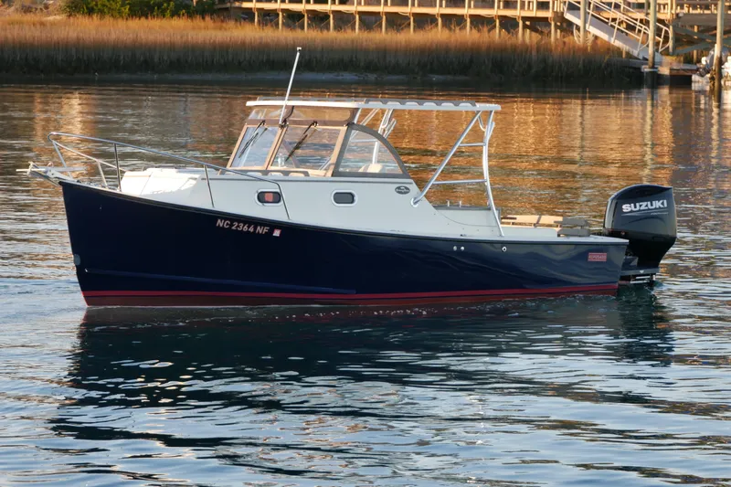 Slide: The Image of 2023 Seaway 24 Seafarer boat with Suzuki outboard engine on calm water. - 6