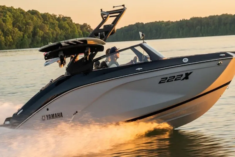 Slide: The Image of 2026 Yamaha Boats 222XE speeding on a lake at sunset. - 2