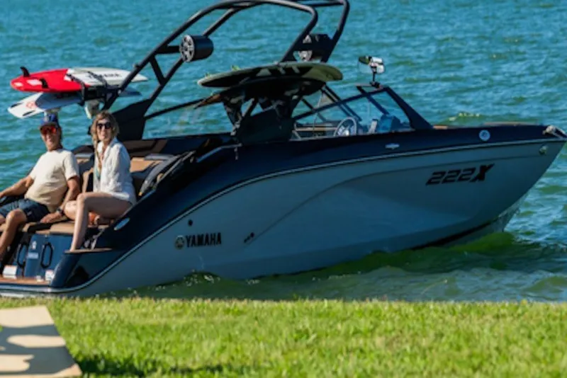 Slide: The Image of 2026 Yamaha Boats 222XE on water with passengers, featuring sleek design and wakeboard. - 4