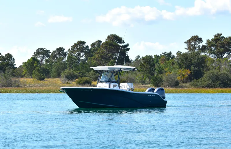 Slide: The Image of 2020 Sea Fox 266 Commander boat on calm water with trees in the background. - 1