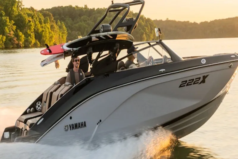 Slide: The Image of 2027 Yamaha Boats 222XD cruising on a lake at sunset, with a wakeboard attached. - 4