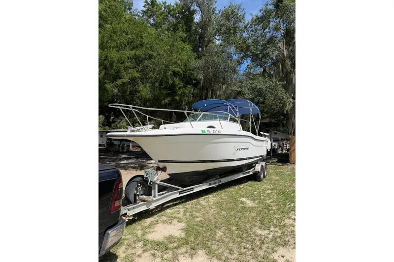 Slide: The Image of 1999 Seaswirl Striper 2301 Walkaround OB on trailer, parked outdoors. - 1