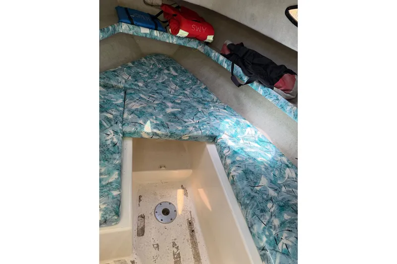 Slide: The Image of 1999 Seaswirl Striper 2301 Walkaround OB cabin interior with patterned cushions and storage space. - 9