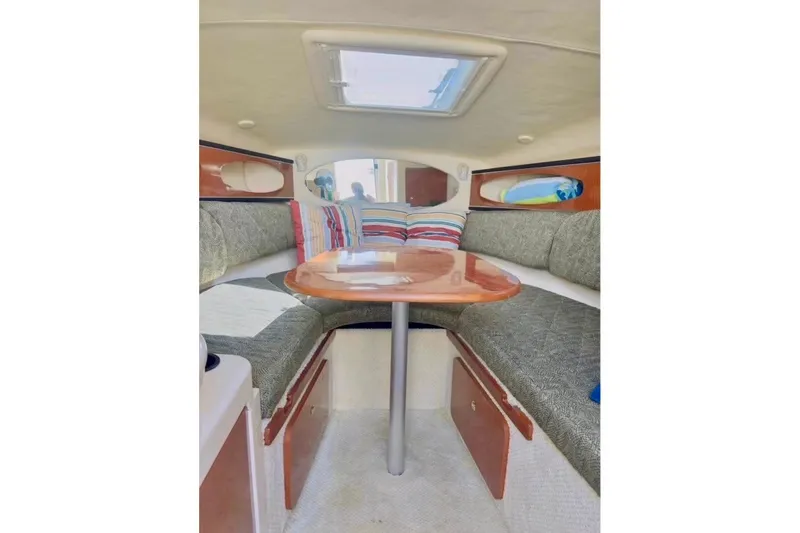 Slide: The Image of Interior of 2003 Sea Ray Sundancer 260 with cozy seating and wooden table. - 5