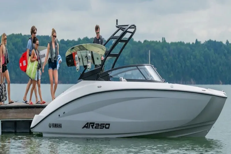 Slide: The Image of 2027 Yamaha Boats AR250 docked with people boarding, ready for a lake adventure. - 2