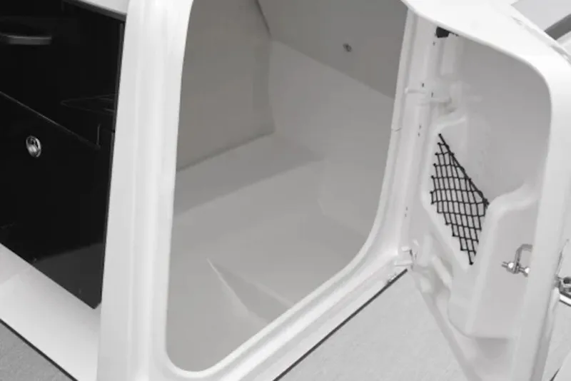 Slide: The Image of 2027 Yamaha Boats AR250 interior storage compartment with open door and netted pocket. - 4