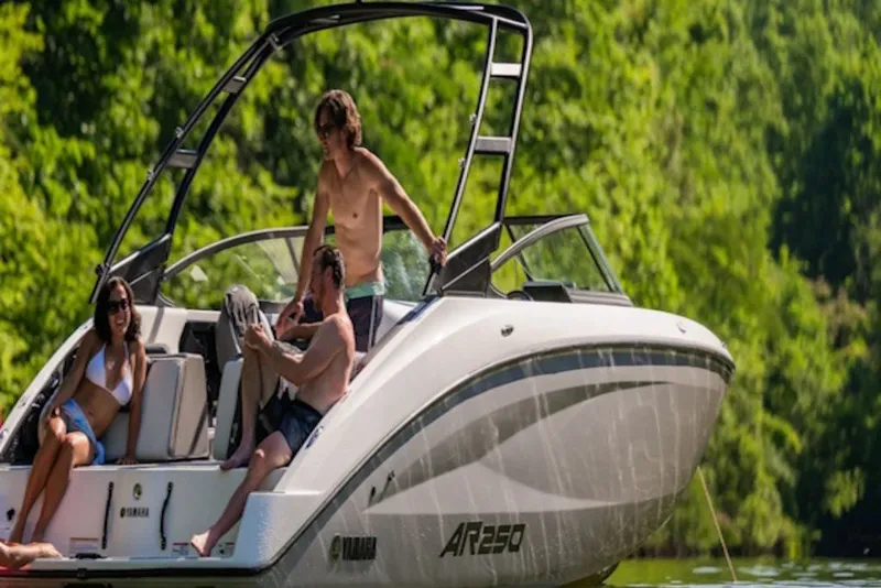 Slide: The Image of 2027 Yamaha Boats AR250 with people enjoying a sunny day on the water. - 8