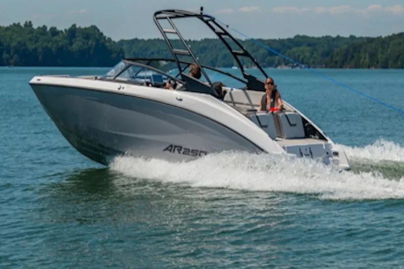 Slide: The Image of 2027 Yamaha Boats AR250 cruising on a scenic lake with passengers enjoying the ride. - 5