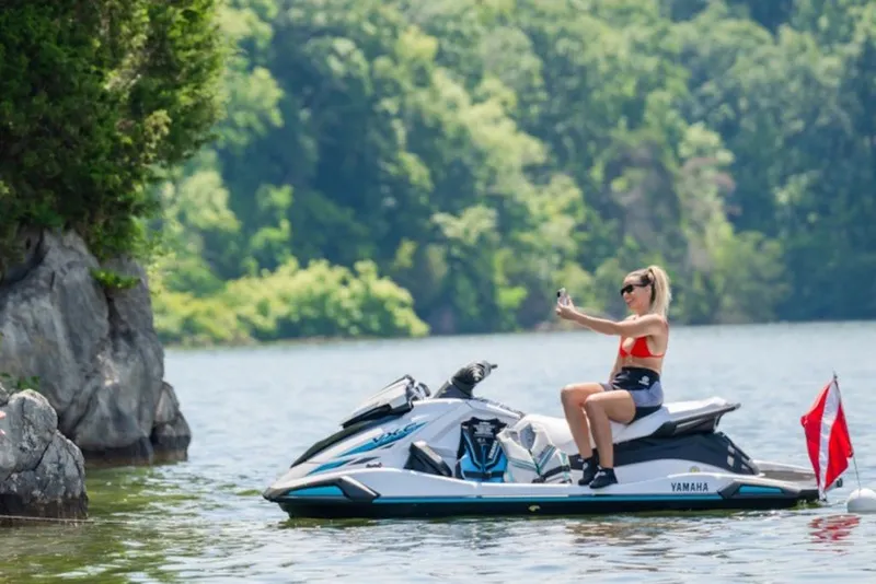 Slide: The Image of Woman on 2027 Yamaha VX-C jet ski taking a selfie on a scenic lake. - 3
