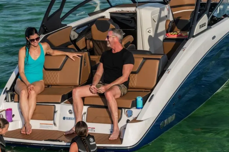 Slide: The Image of 2026 Yamaha Boats 252SD with people relaxing on deck in sunny waters. - 5