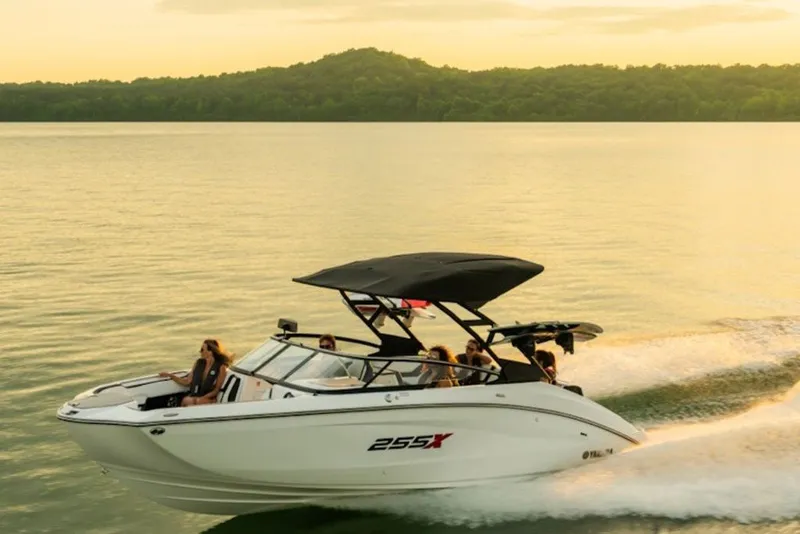 Slide: The Image of 2027 Yamaha Boats 255XD cruising on a serene lake at sunset. - 3