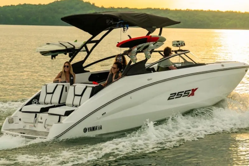 Slide: The Image of 2027 Yamaha Boats 255XD cruising on a lake at sunset with passengers onboard. - 10