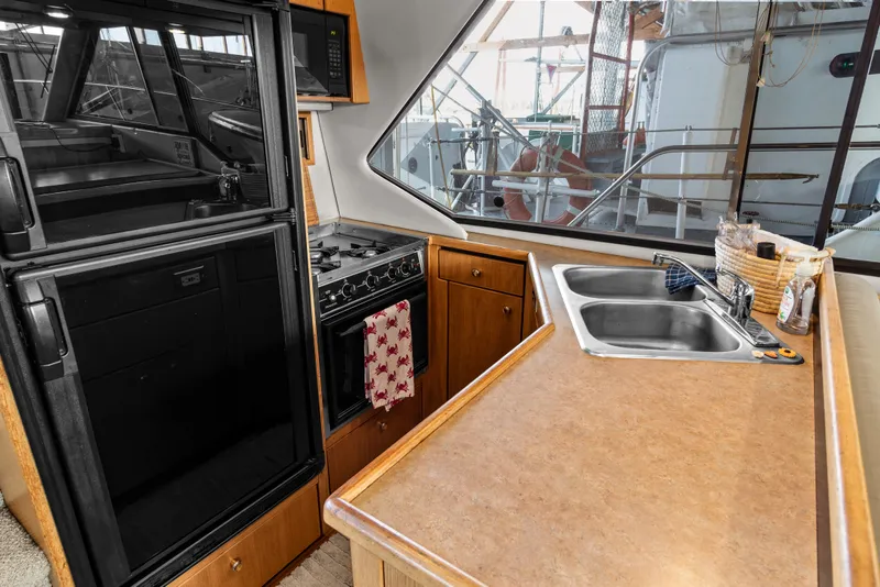 Slide: The Image of 2000 Bayliner 4087 Aft Cabin Motoryacht kitchen with stove, sink, and refrigerator. - 16